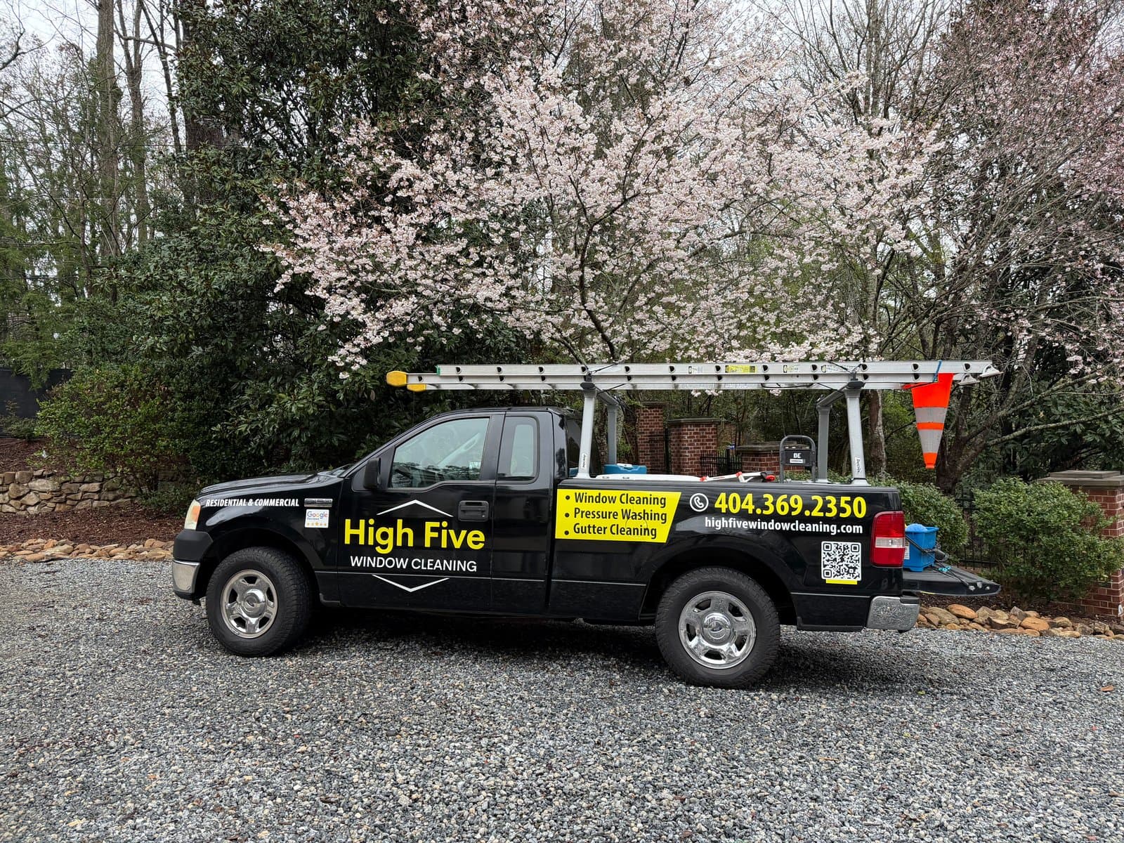 High Five Window Cleaning truck, with ladders, parked at an Atlanta-area home